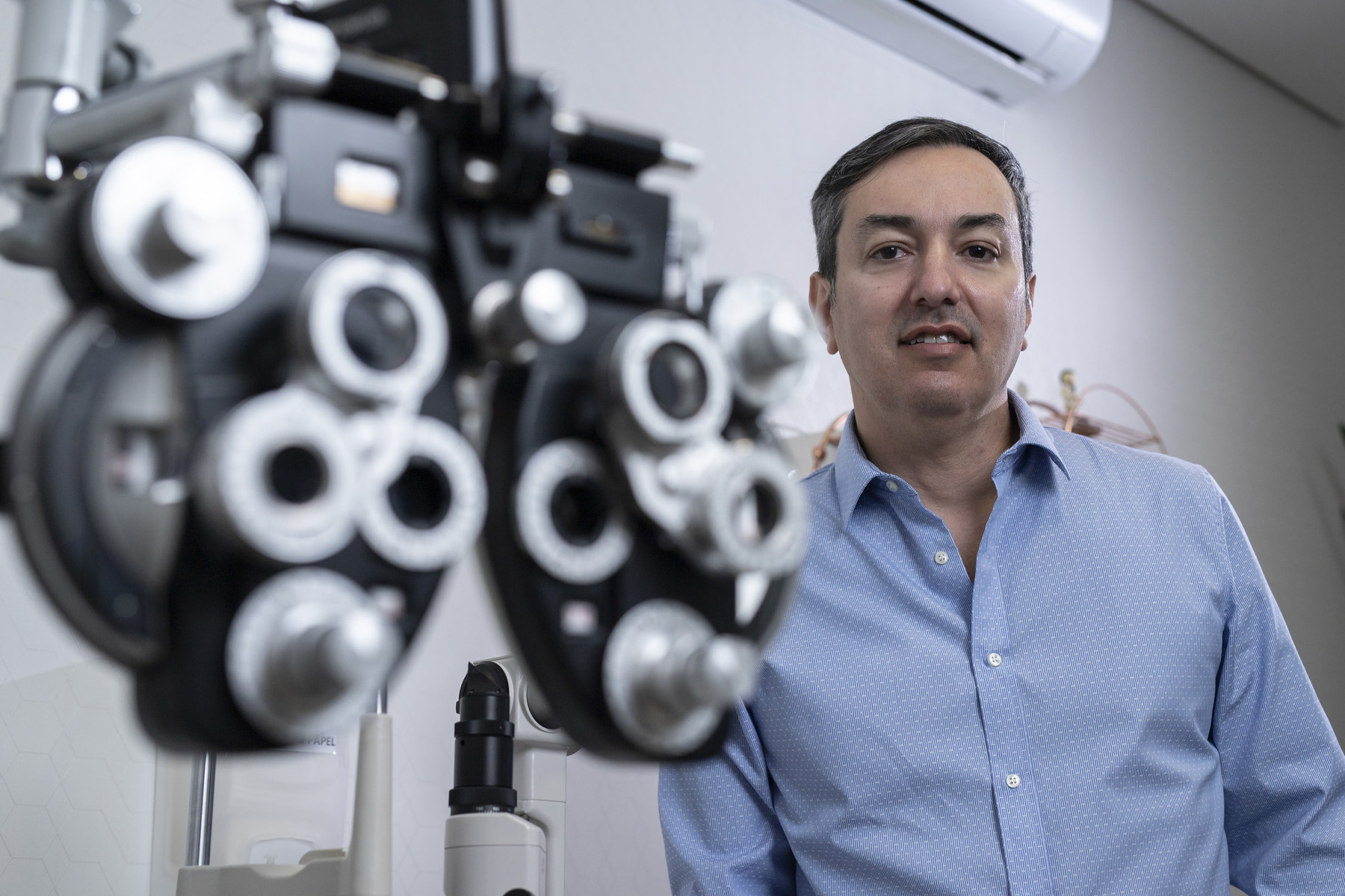 Dr. Roberto Márcio ao lado de equipamentos de avaliação oftalmológica